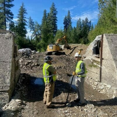 Two construction workers help remove a dam in Montana.