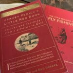 The red covers of two books about golf and fly fishing