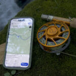 A fishing ole and a smart phone that shows a map of Iron Ore Knob